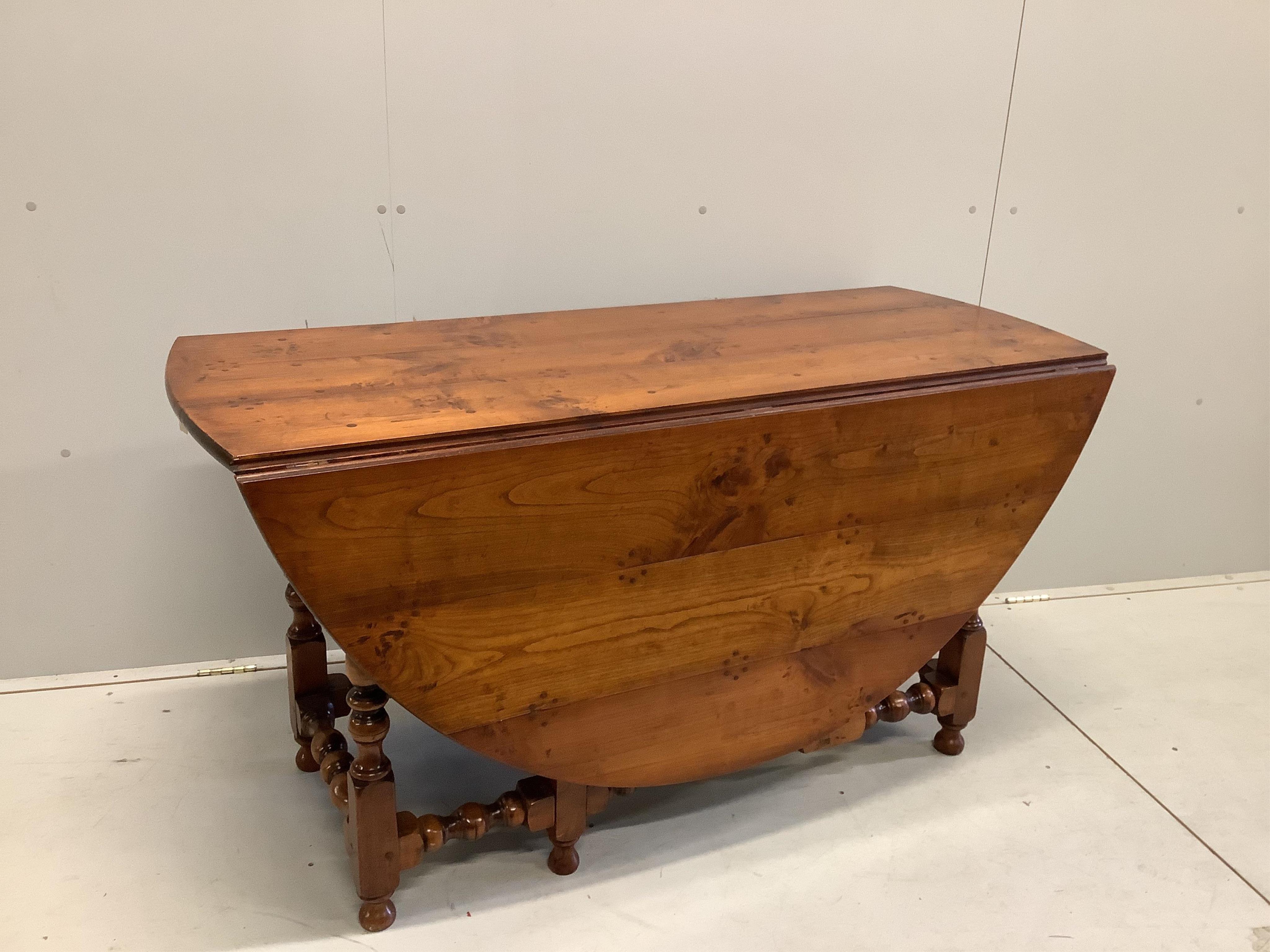 A reproduction 18th century style elm gateleg dining table on turned baluster under frame, width 169cm extended, depth 142cm, height 75cm. Condition - good with a rich colour.